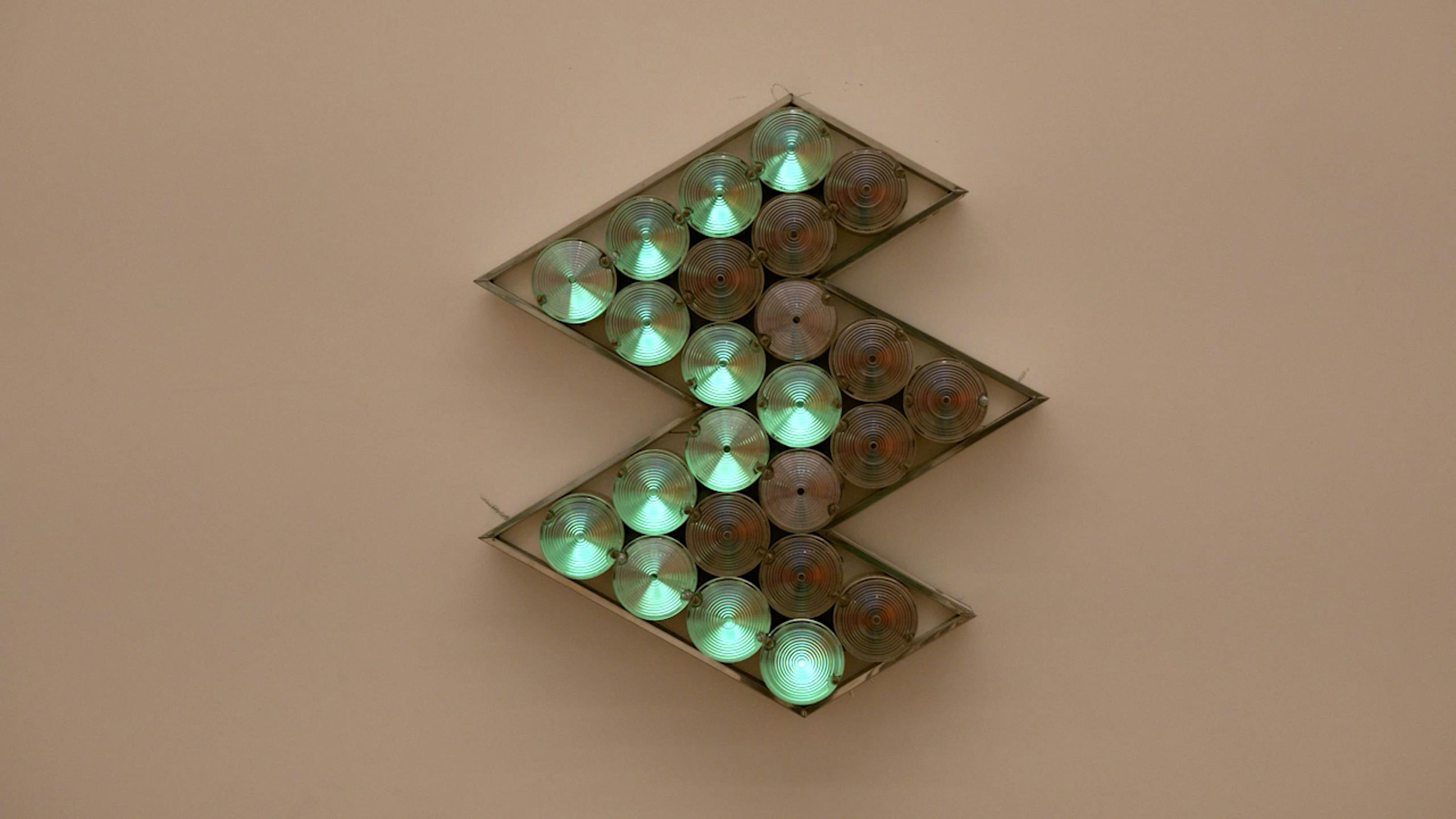 An electronically powered light sculpture with different color lightbulbs lighting up in different sequences.