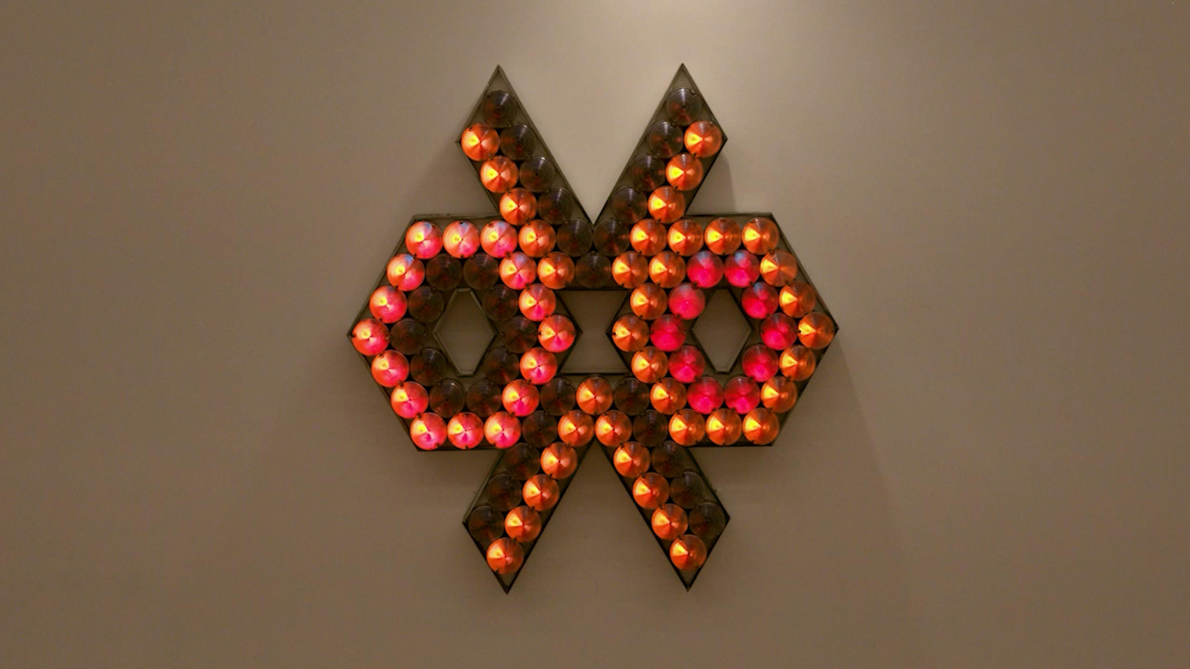 An electronically powered light sculpture with different color lightbulbs lighting up in different sequences.