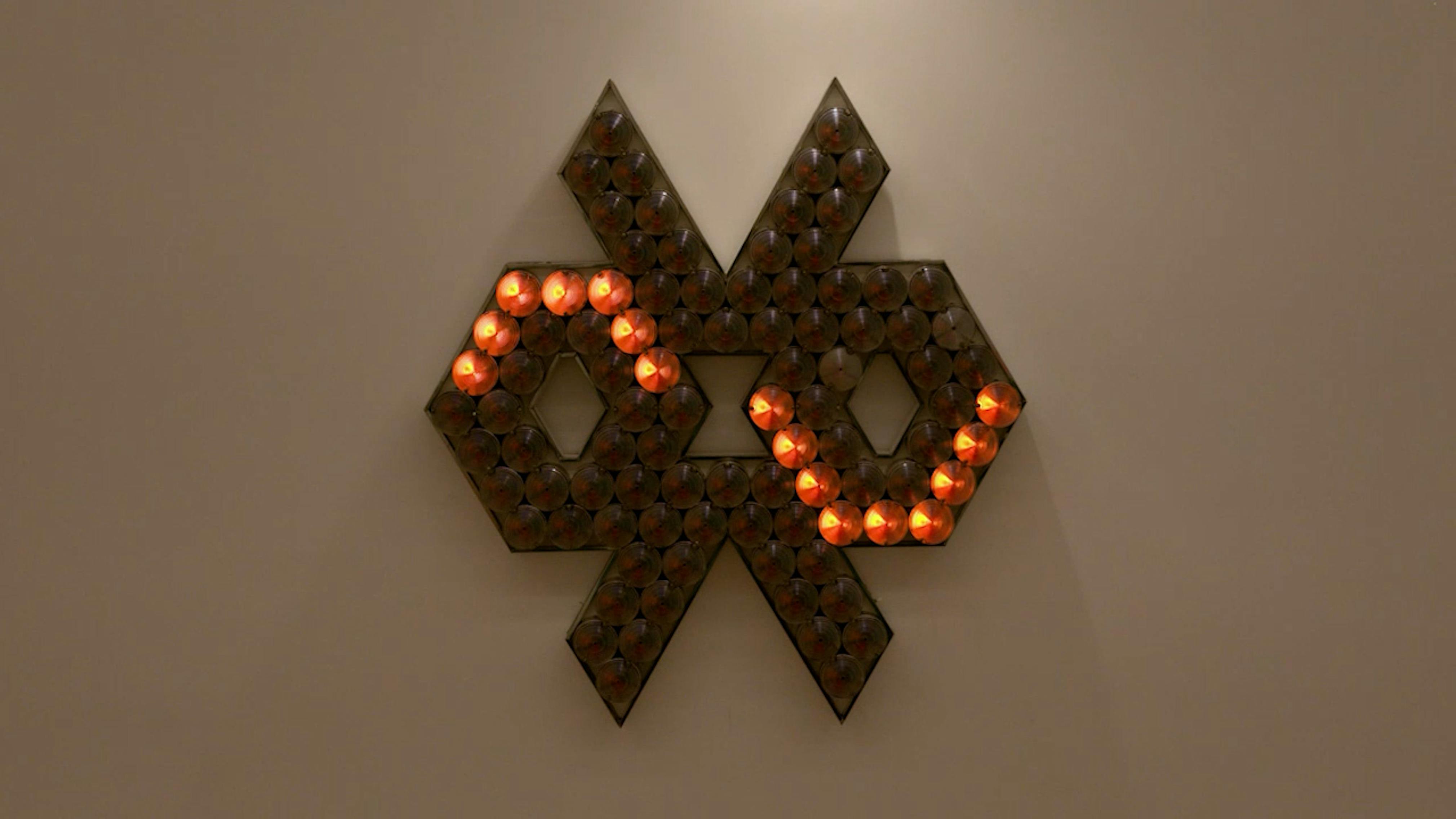 An electronically powered light sculpture with different color lightbulbs lighting up in different sequences.