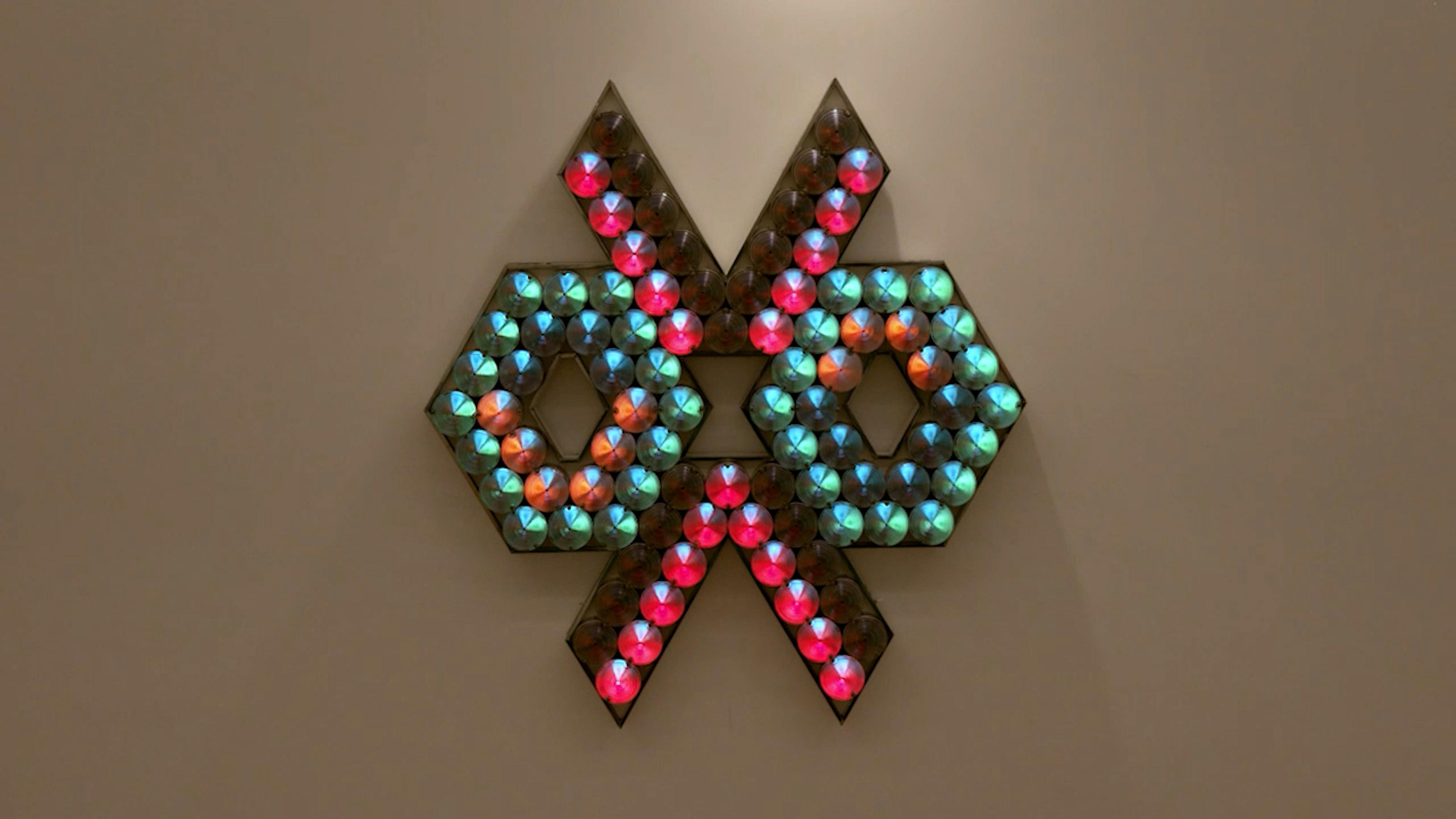 An electronically powered light sculpture with different color lightbulbs lighting up in different sequences.