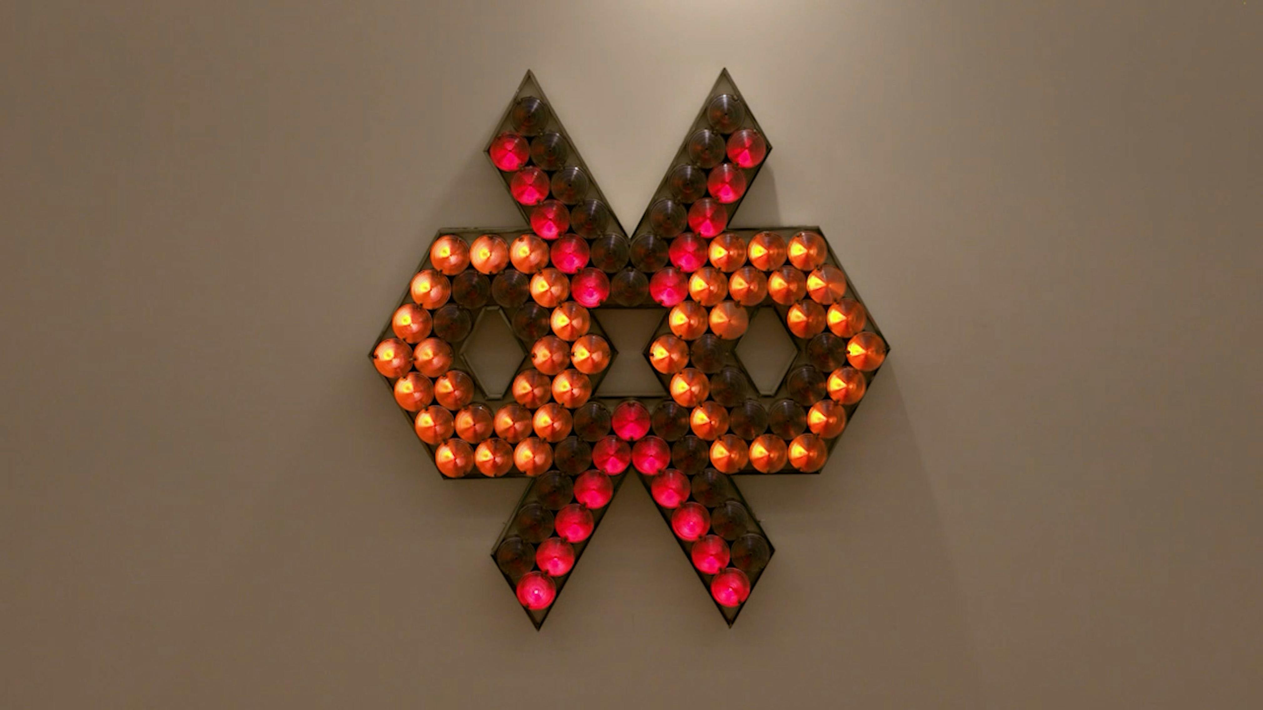 An electronically powered light sculpture with different color lightbulbs lighting up in different sequences.