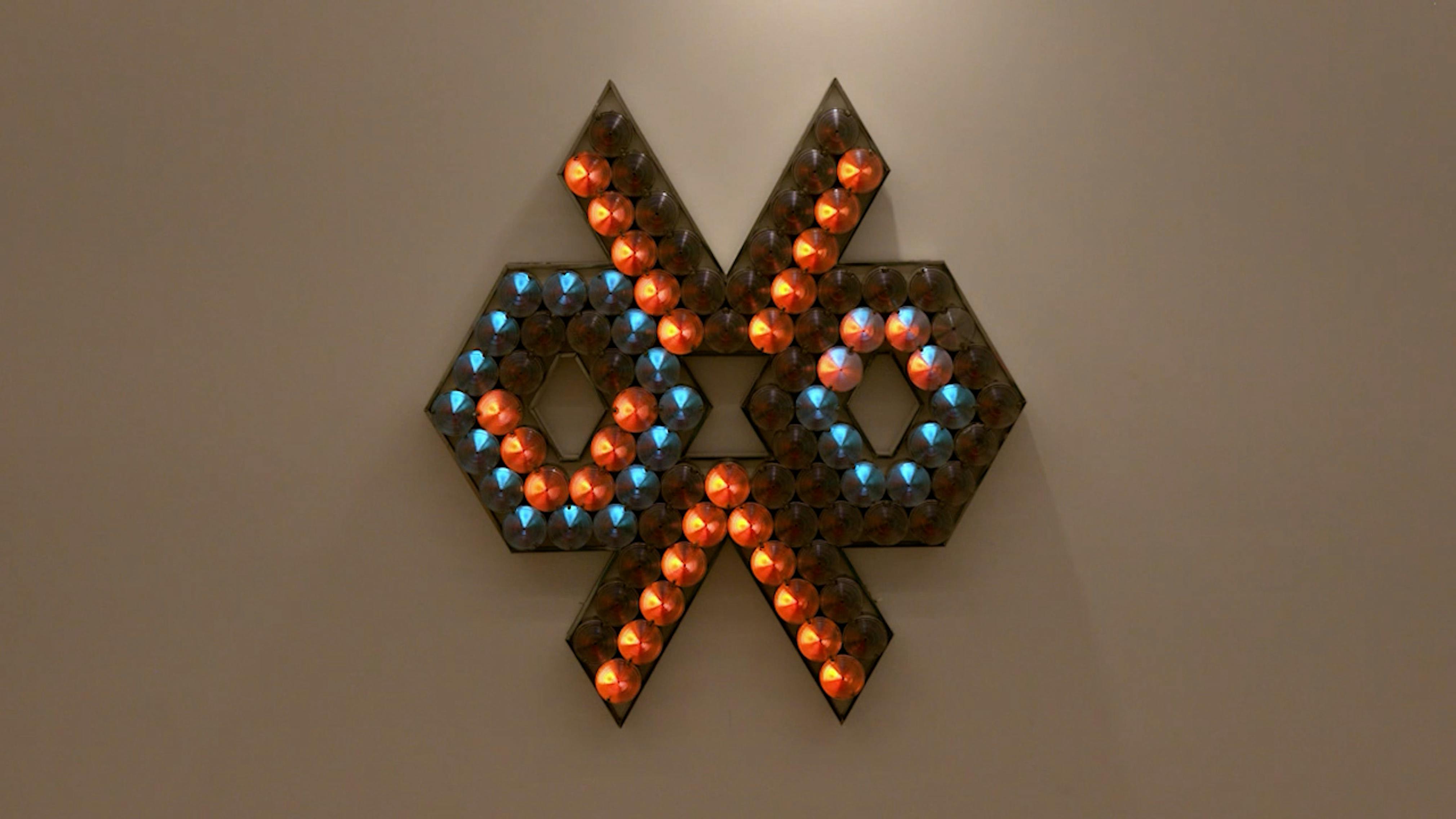 An electronically powered light sculpture with different color lightbulbs lighting up in different sequences.