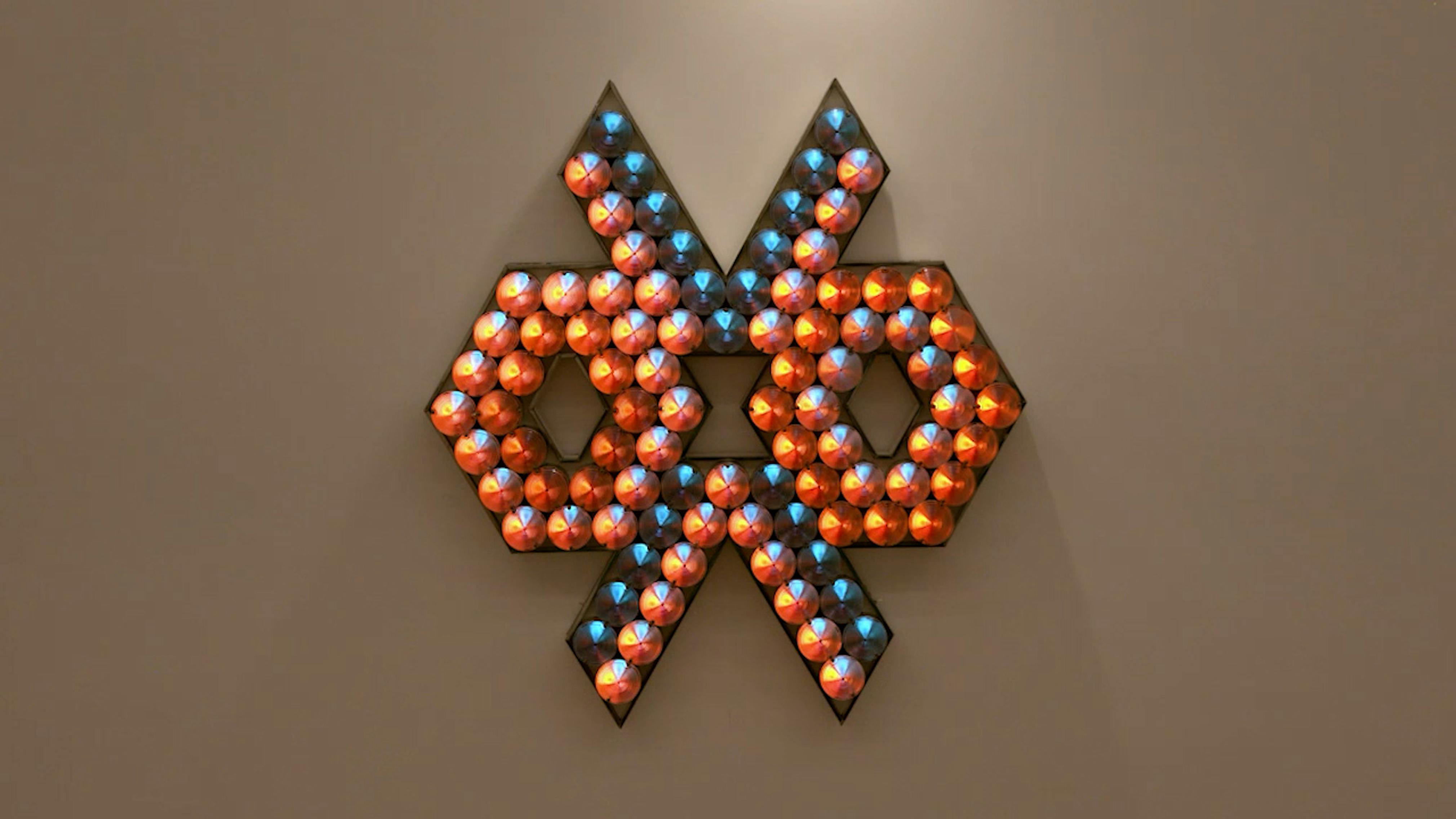 An electronically powered light sculpture with different color lightbulbs lighting up in different sequences.