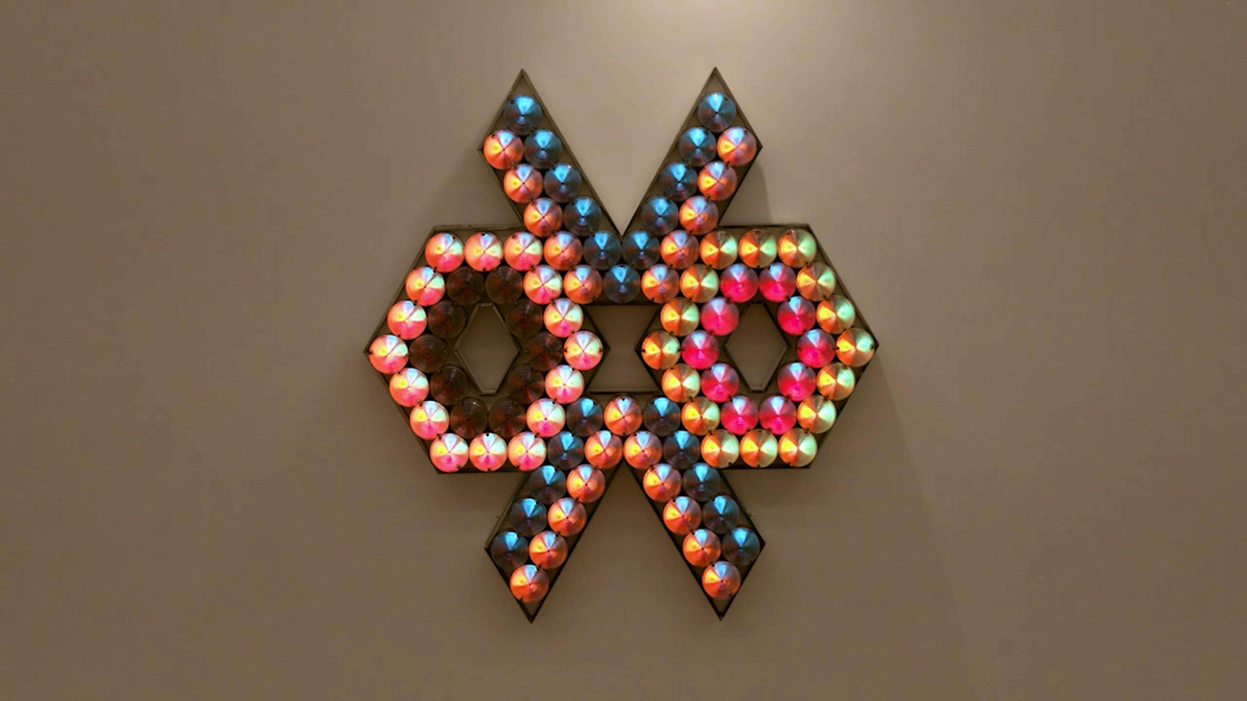 An electronically powered light sculpture with different color lightbulbs lighting up in different sequences.