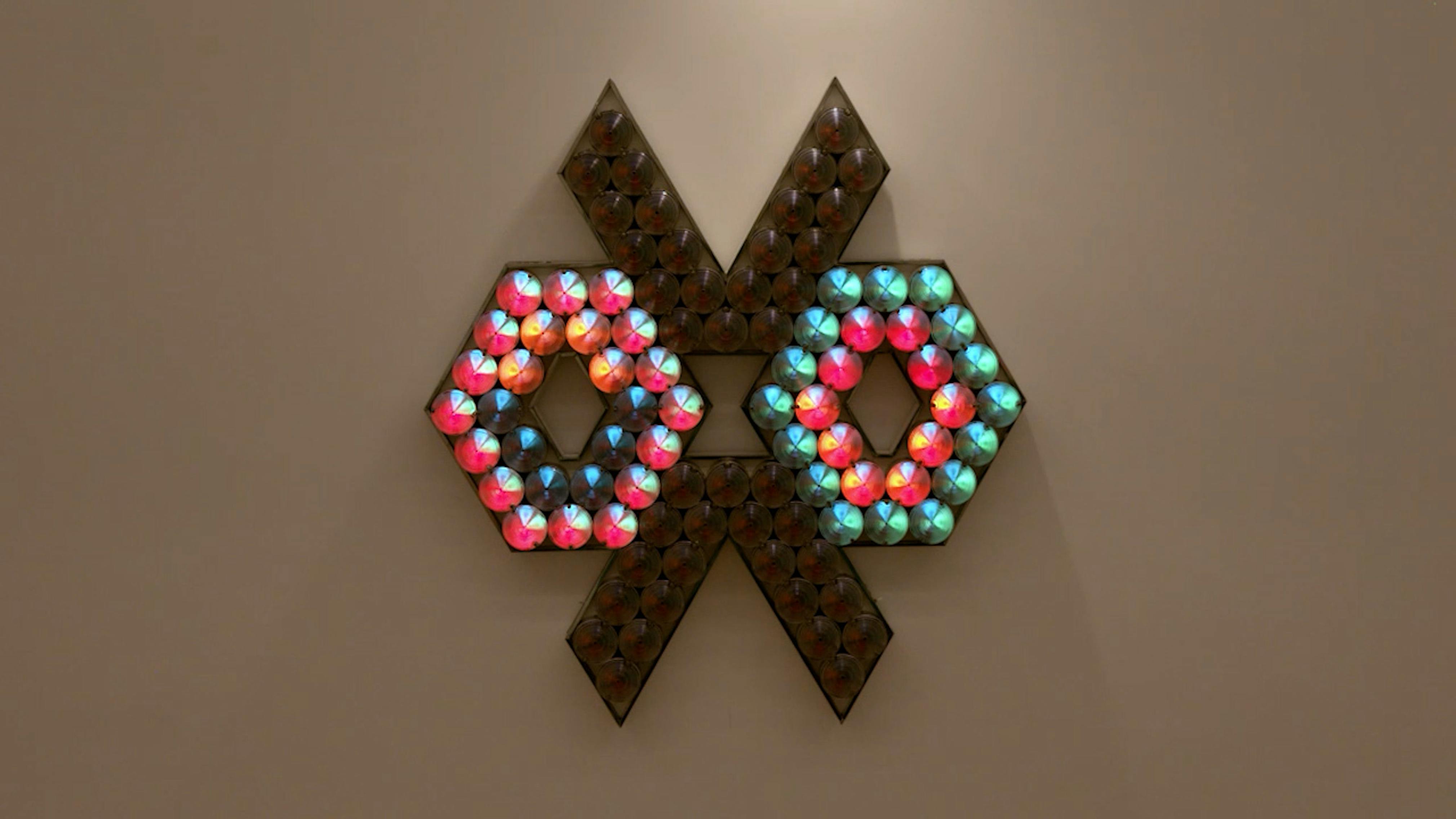 An electronically powered light sculpture with different color lightbulbs lighting up in different sequences.