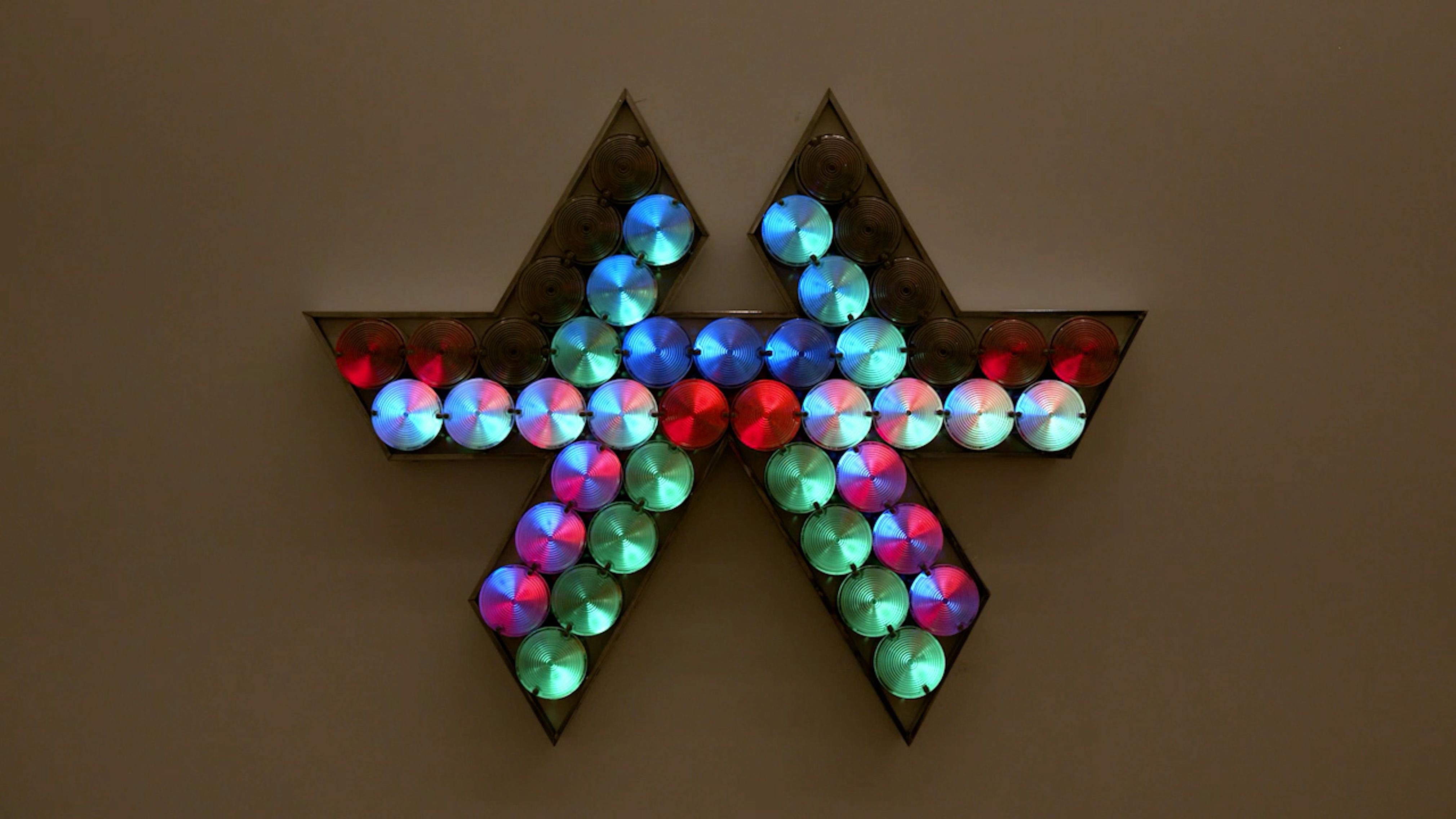 An electronically powered light sculpture with different color lightbulbs lighting up in different sequences.