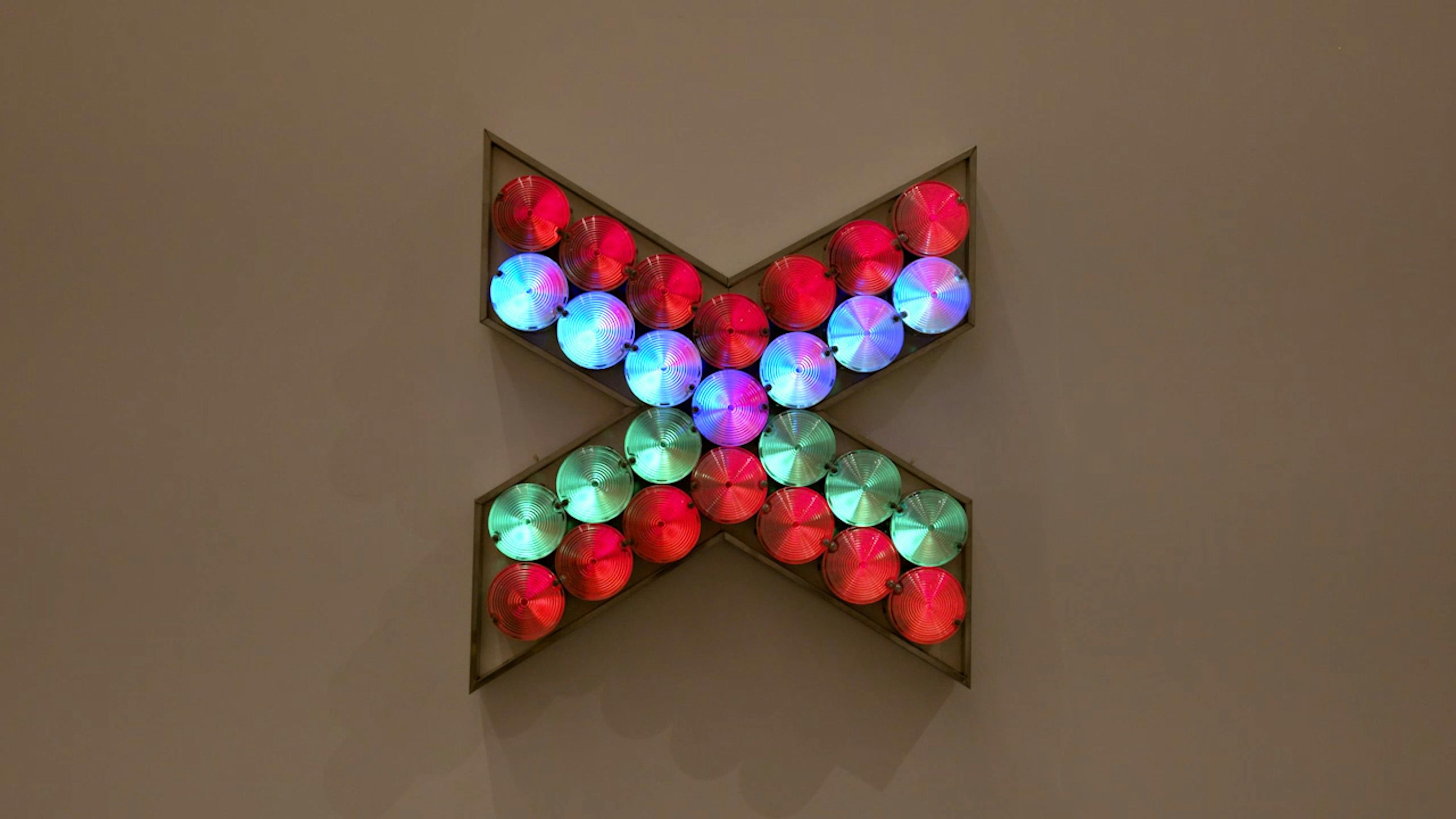 An electronically powered light sculpture with different color lightbulbs lighting up in different sequences.