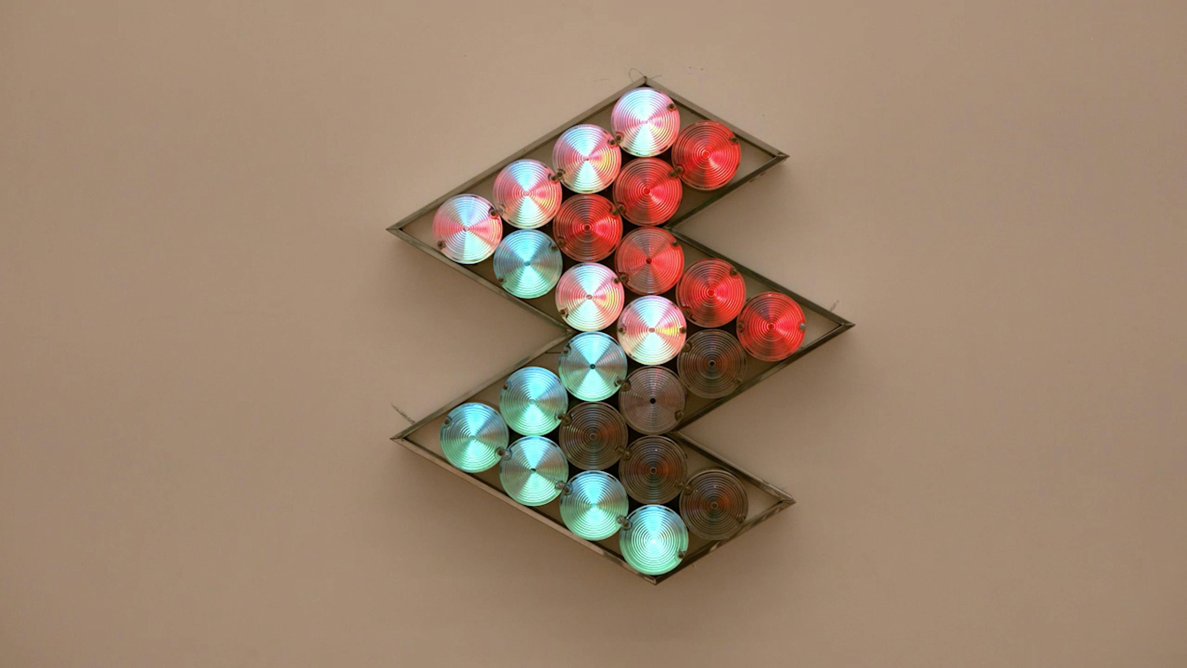 An electronically powered light sculpture with different color lightbulbs lighting up in different sequences.