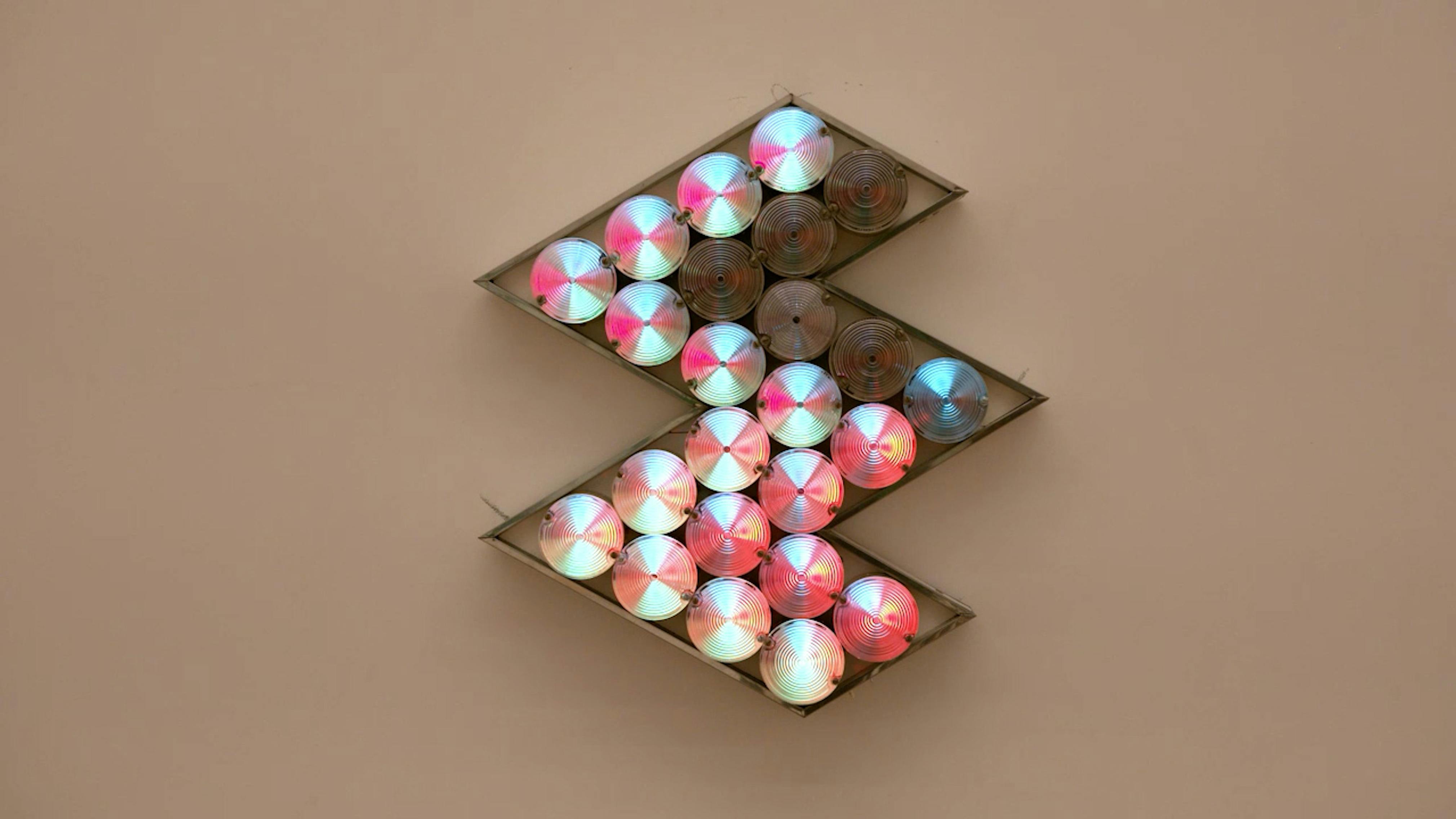 An electronically powered light sculpture with different color lightbulbs lighting up in different sequences.