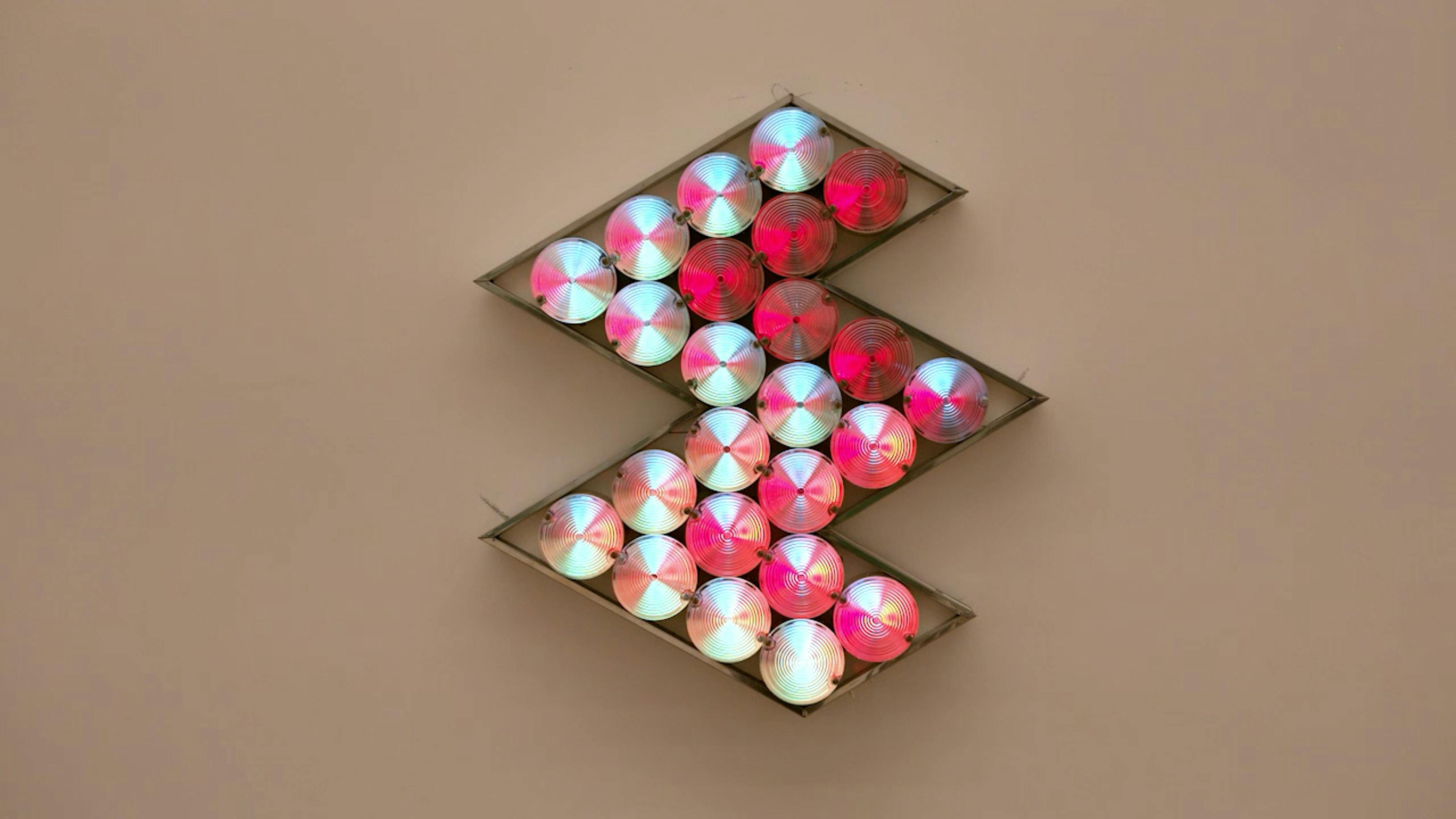 An electronically powered light sculpture with different color lightbulbs lighting up in different sequences.