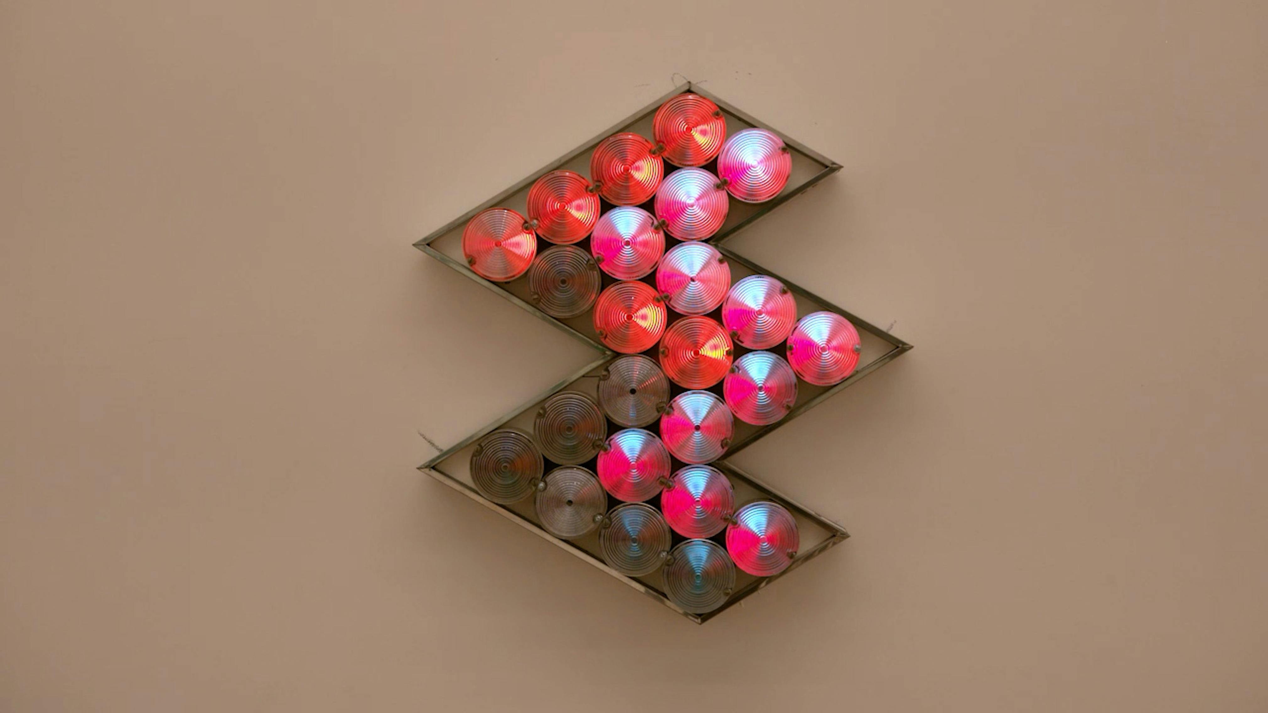 An electronically powered light sculpture with different color lightbulbs lighting up in different sequences.