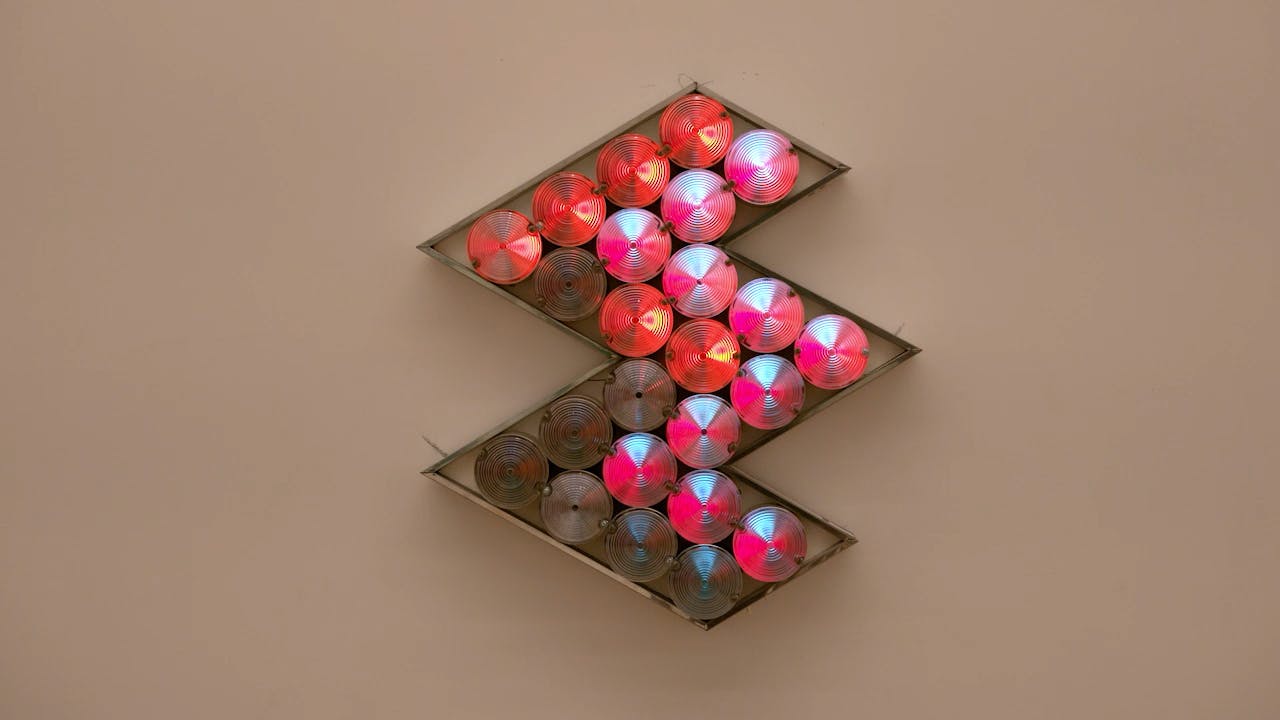 An electronically powered light sculpture with different color lightbulbs lighting up in different sequences.