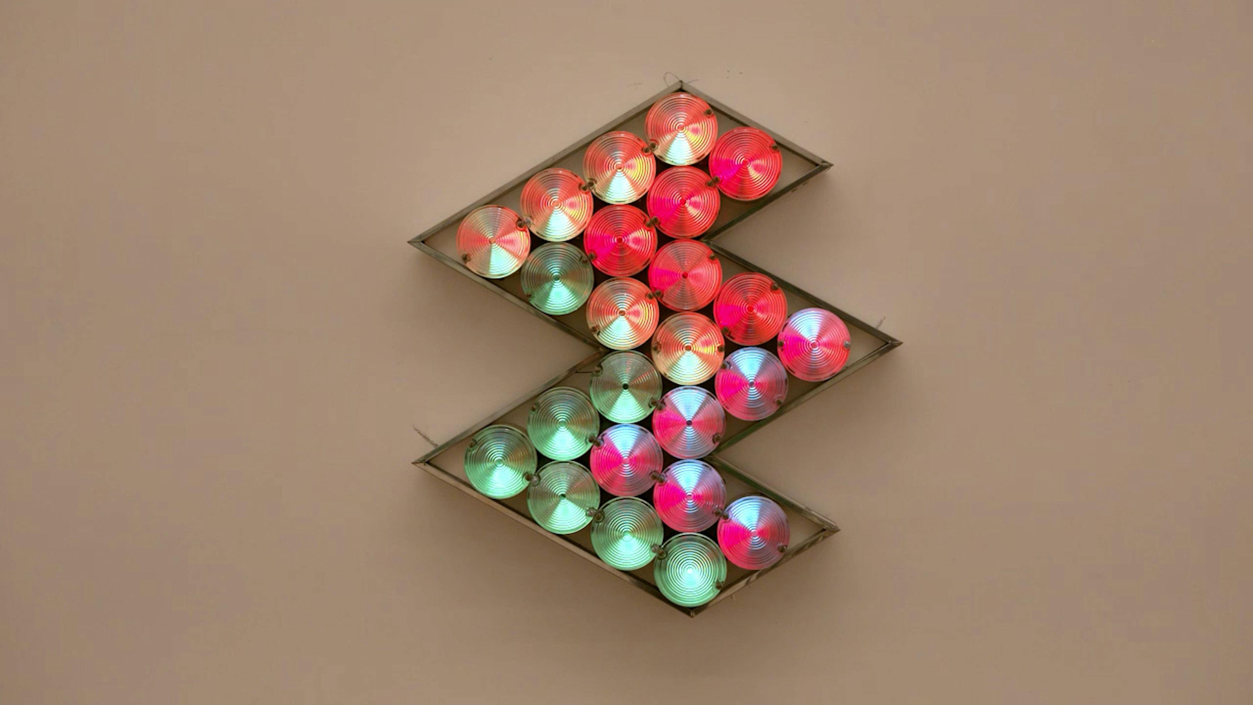 An electronically powered light sculpture with different color lightbulbs lighting up in different sequences.