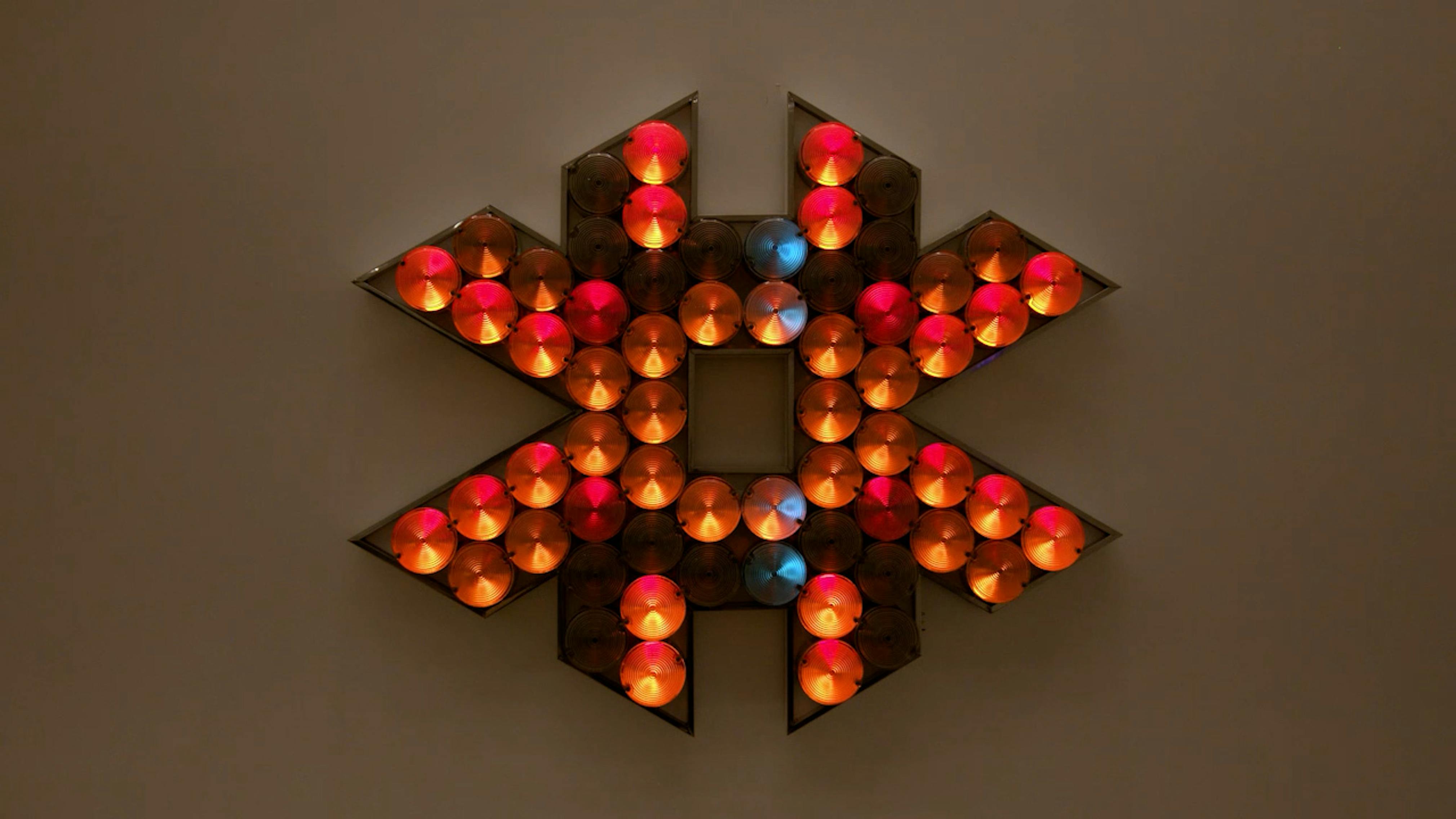 An electronically powered light sculpture with different color lightbulbs lighting up in different sequences.