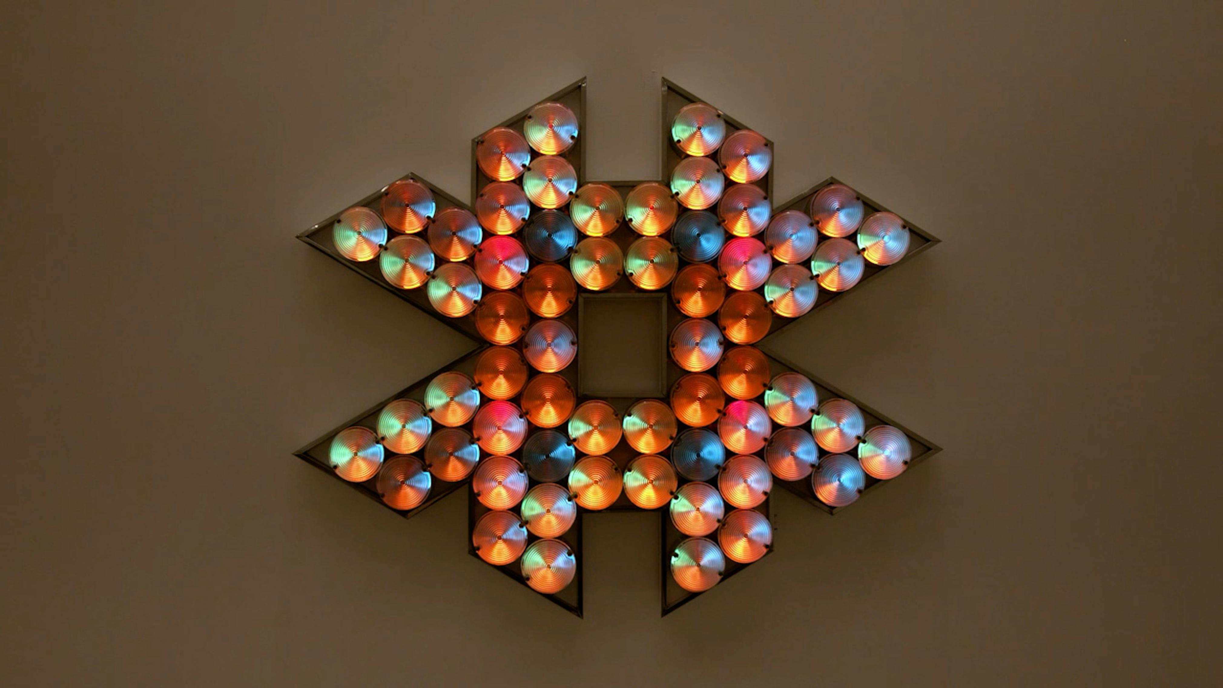An electronically powered light sculpture with different color lightbulbs lighting up in different sequences.