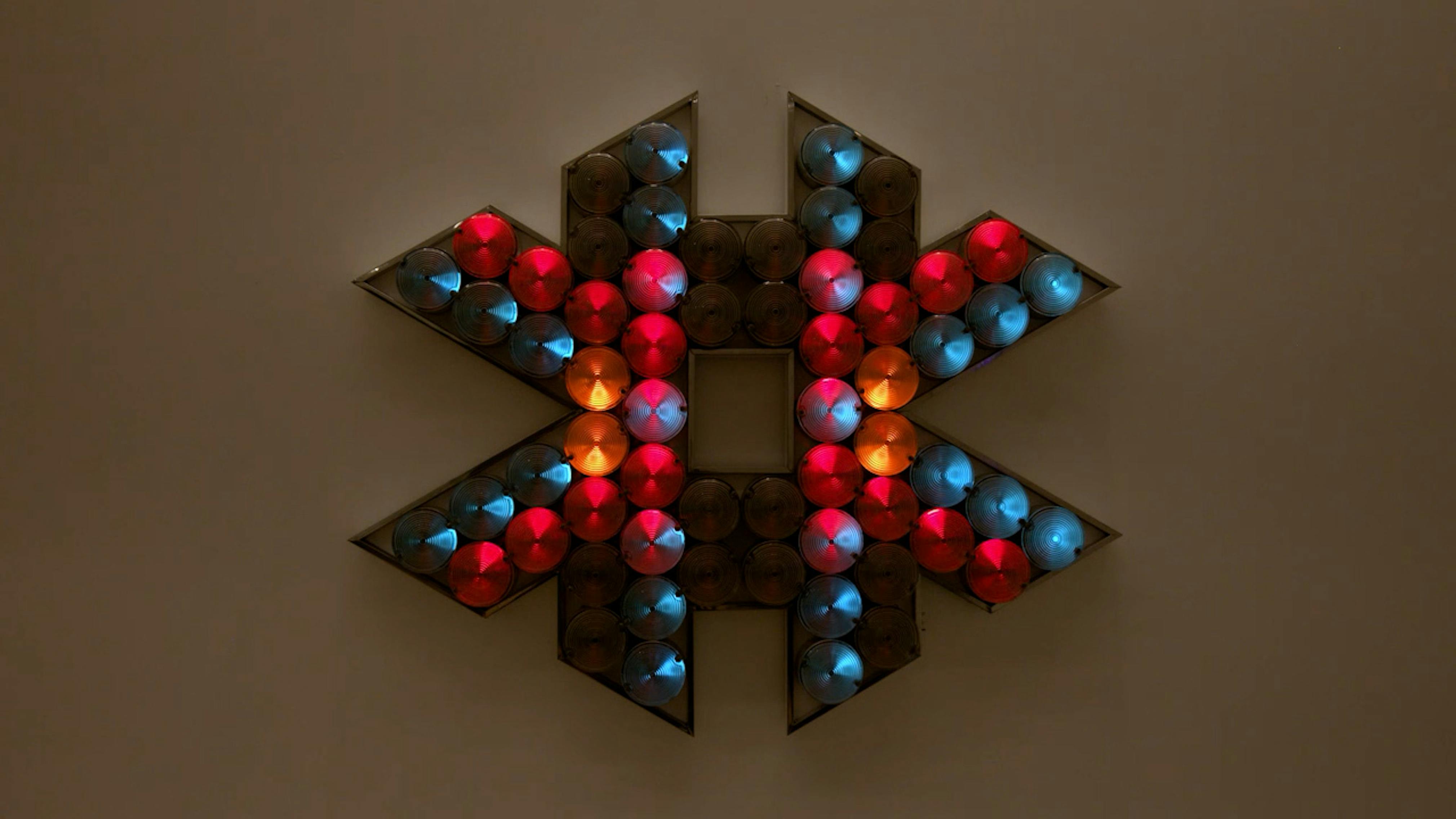 An electronically powered light sculpture with different color lightbulbs lighting up in different sequences.
