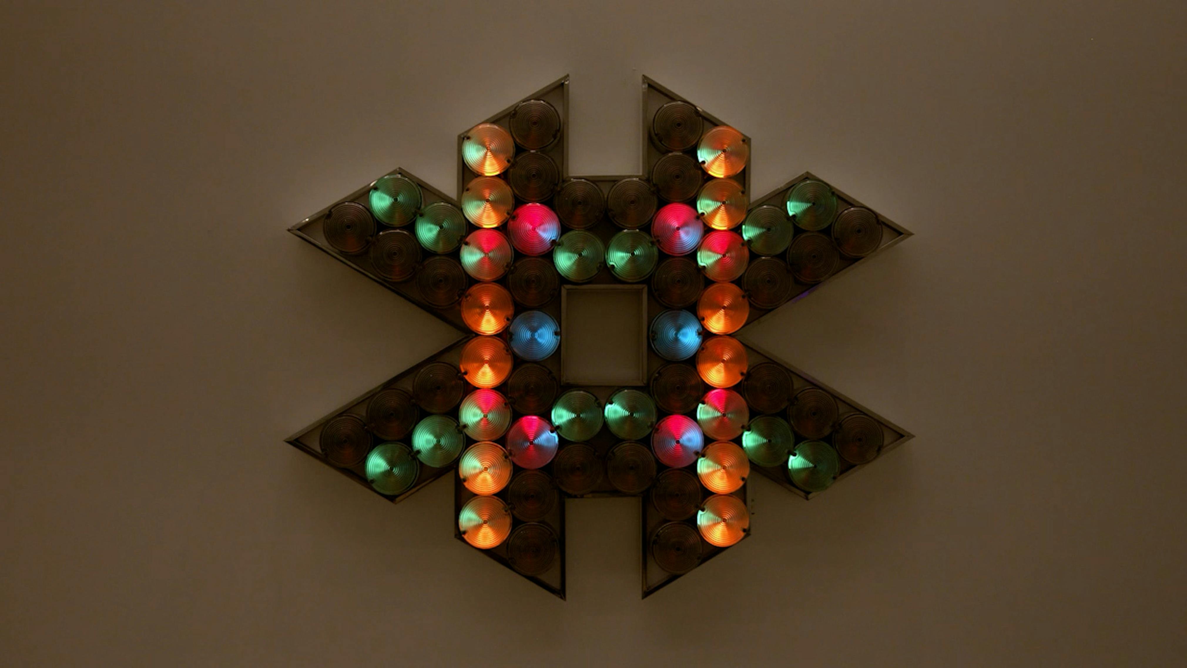 An electronically powered light sculpture with different color lightbulbs lighting up in different sequences.
