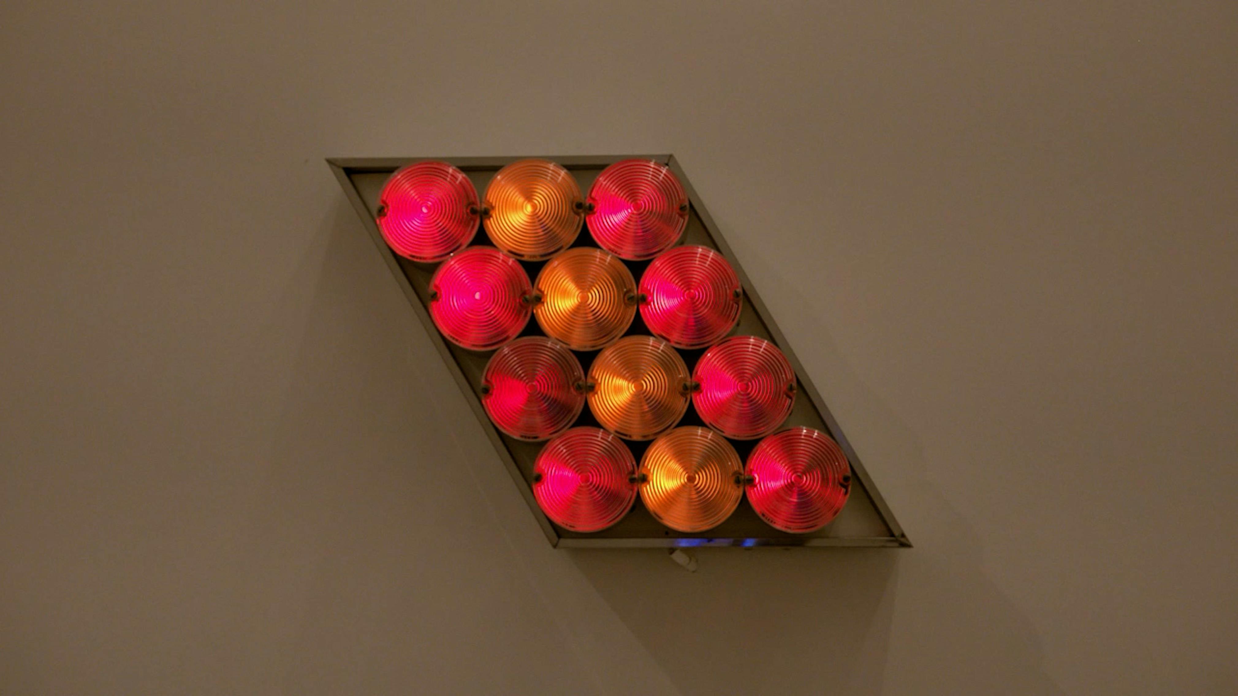 An electronically powered light sculpture with different color lightbulbs lighting up in different sequences.