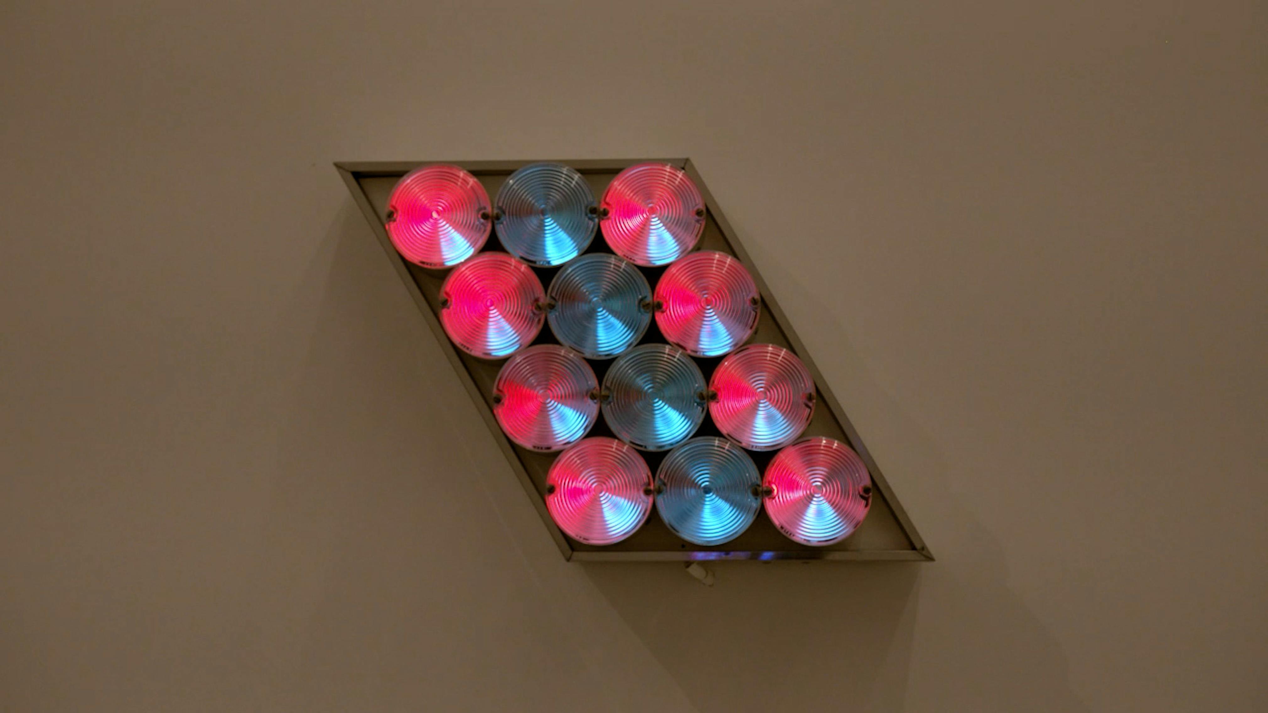 An electronically powered light sculpture with different color lightbulbs lighting up in different sequences.