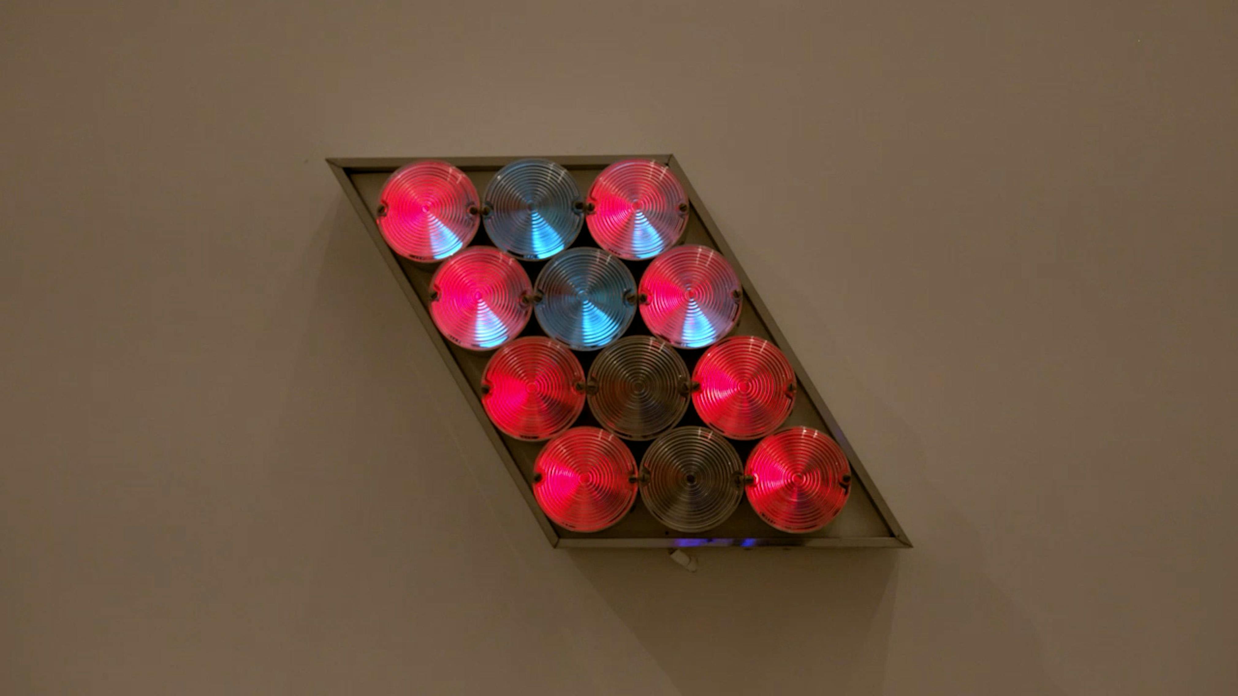 An electronically powered light sculpture with different color lightbulbs lighting up in different sequences.