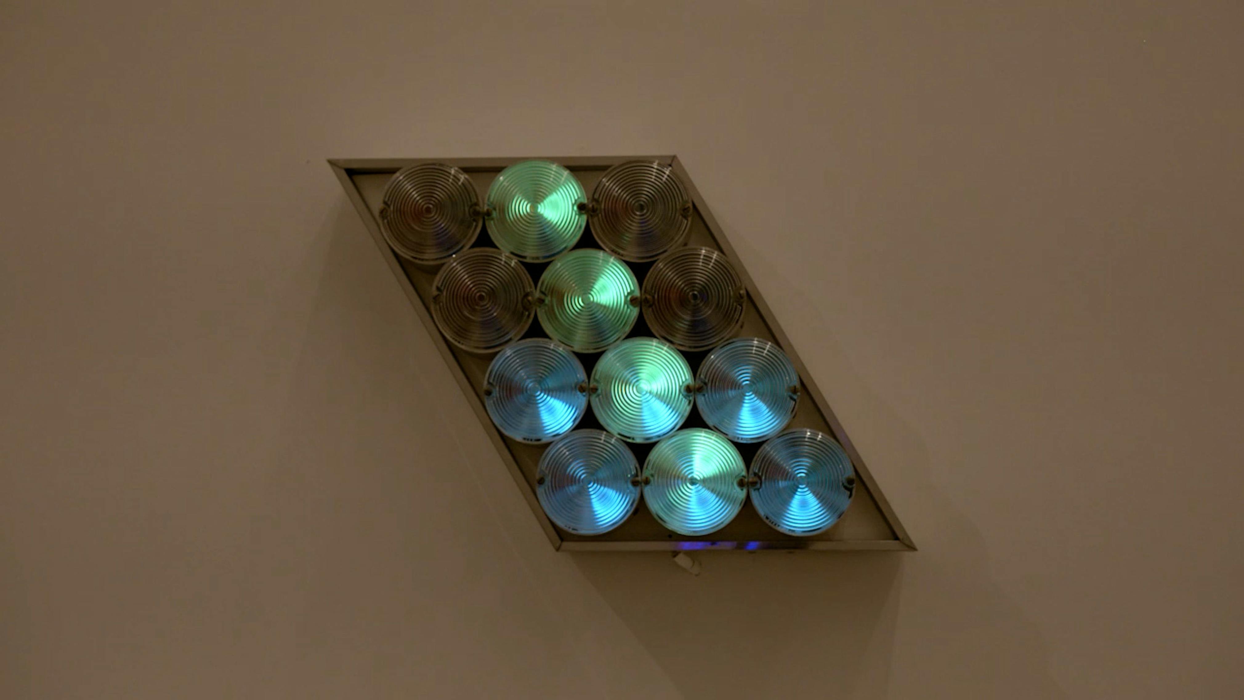 An electronically powered light sculpture with different color lightbulbs lighting up in different sequences.