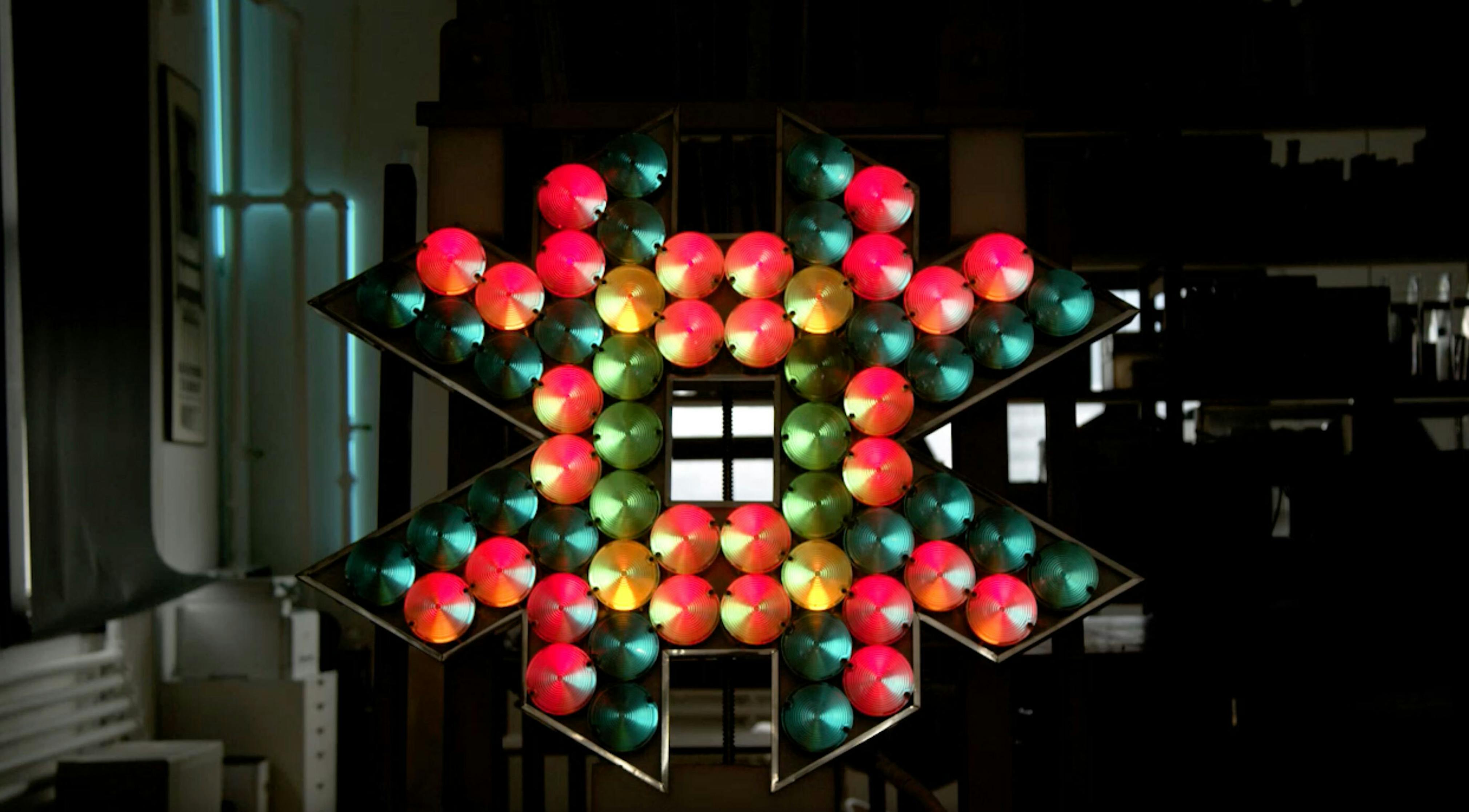 An electronically powered light sculpture with different color lightbulbs lighting up in different sequences.