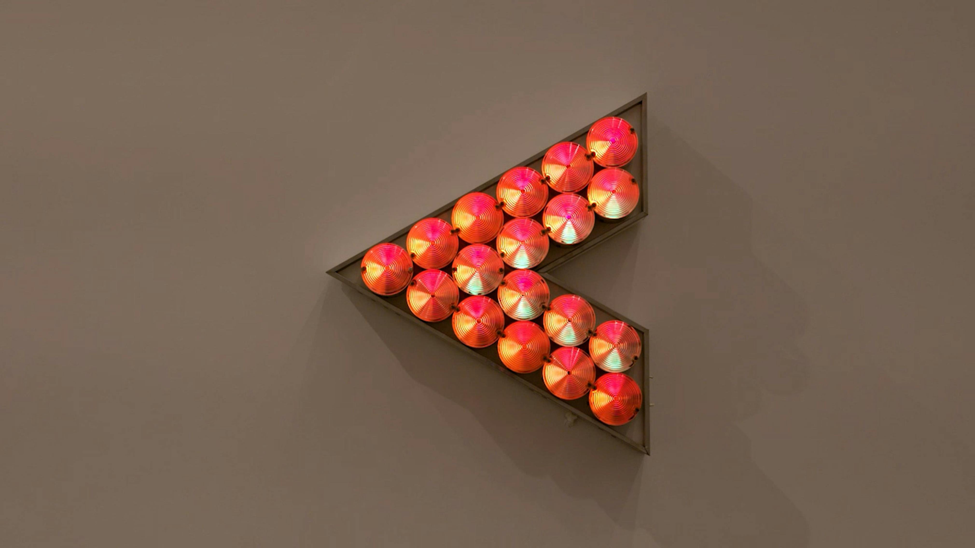 An electronically powered light sculpture with different color lightbulbs lighting up in different sequences.