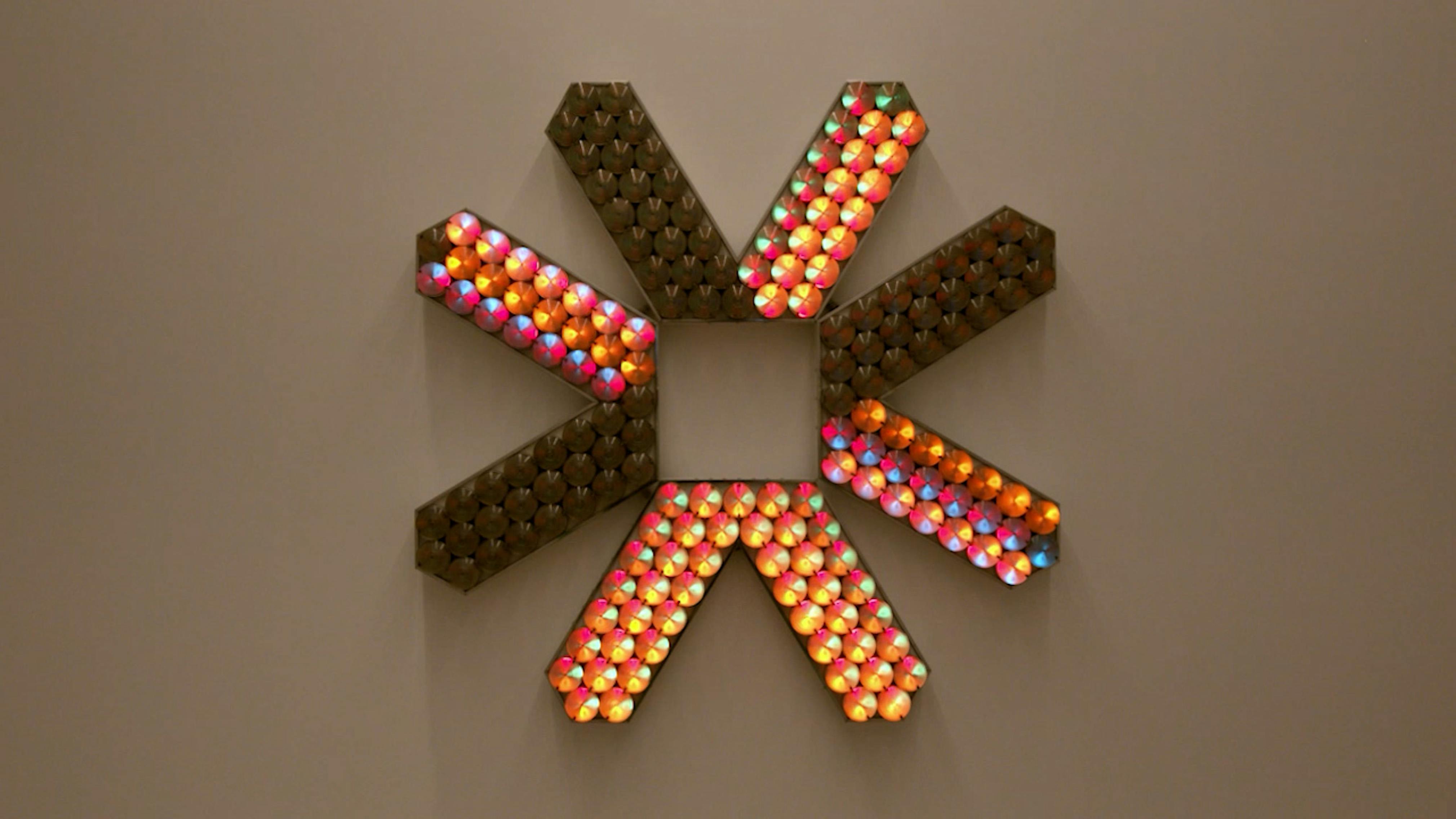 An electronically powered light sculpture with different color lightbulbs lighting up in different sequences.