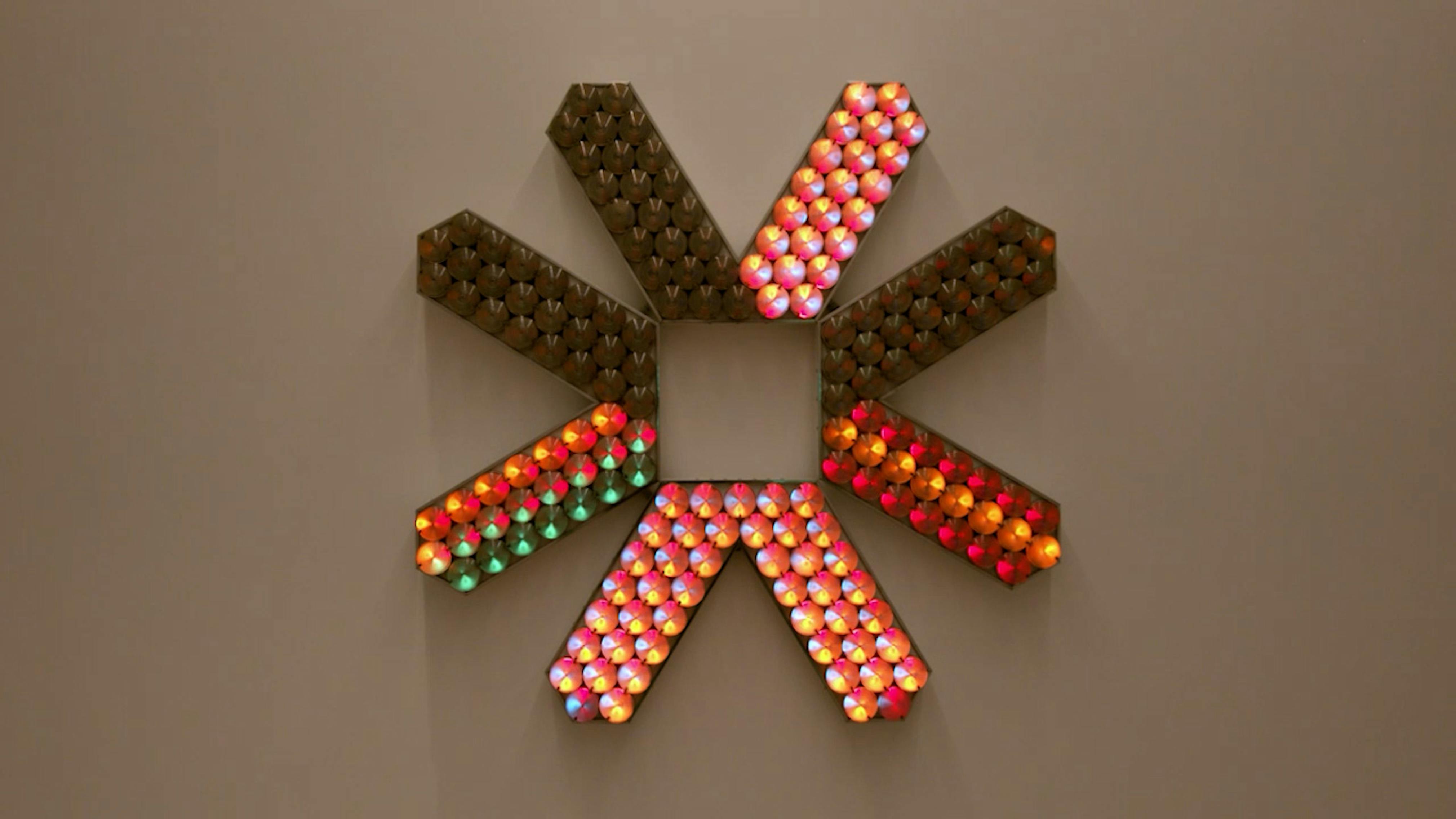 An electronically powered light sculpture with different color lightbulbs lighting up in different sequences.