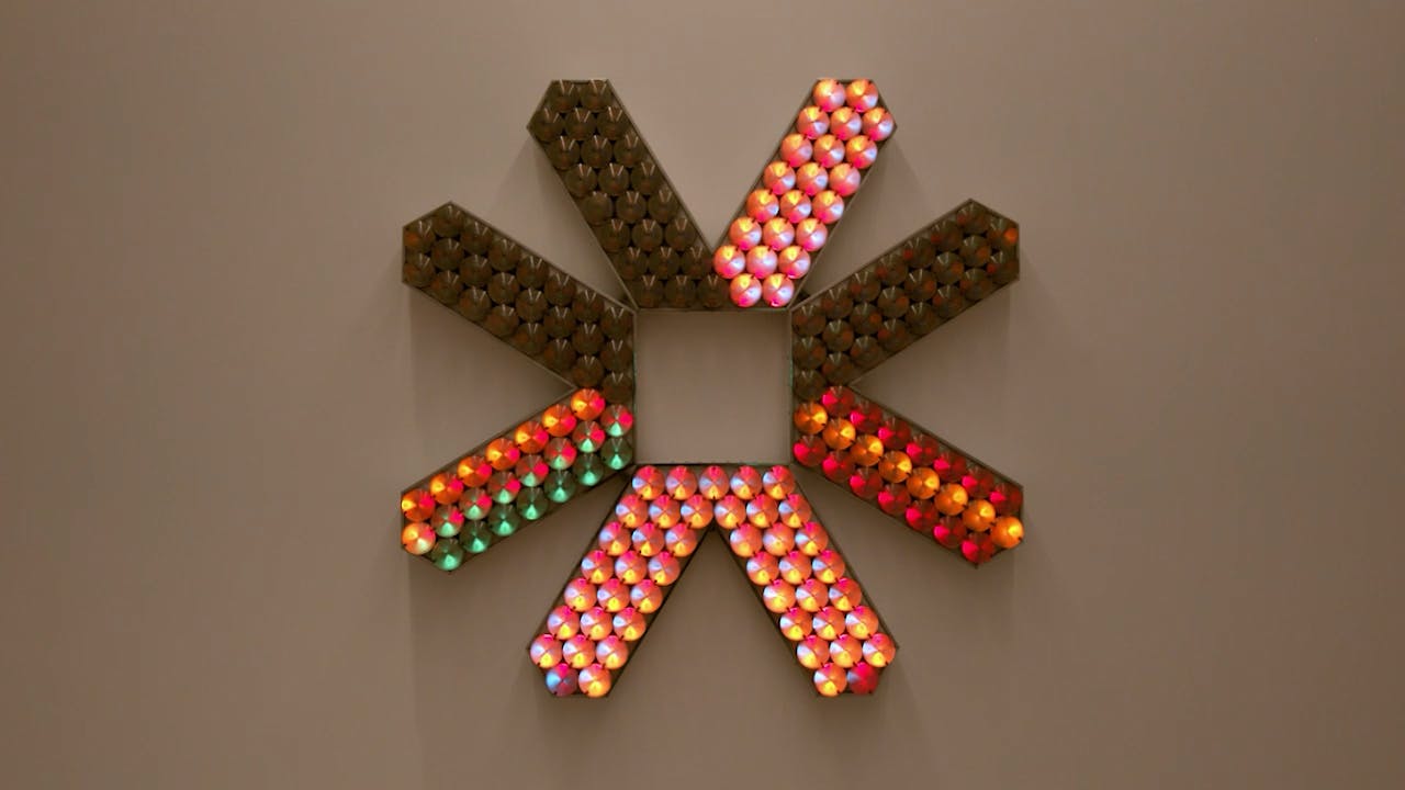 An electronically powered light sculpture with different color lightbulbs lighting up in different sequences.