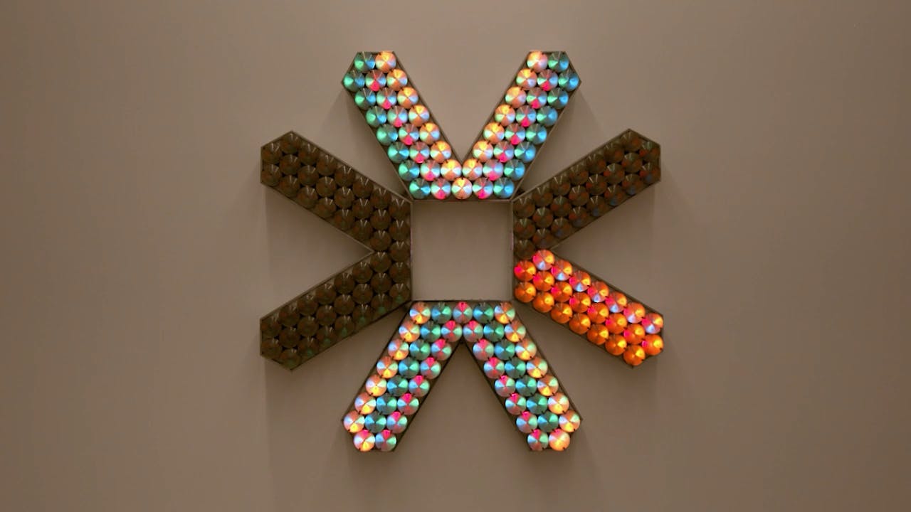 An electronically powered light sculpture with different color lightbulbs lighting up in different sequences.