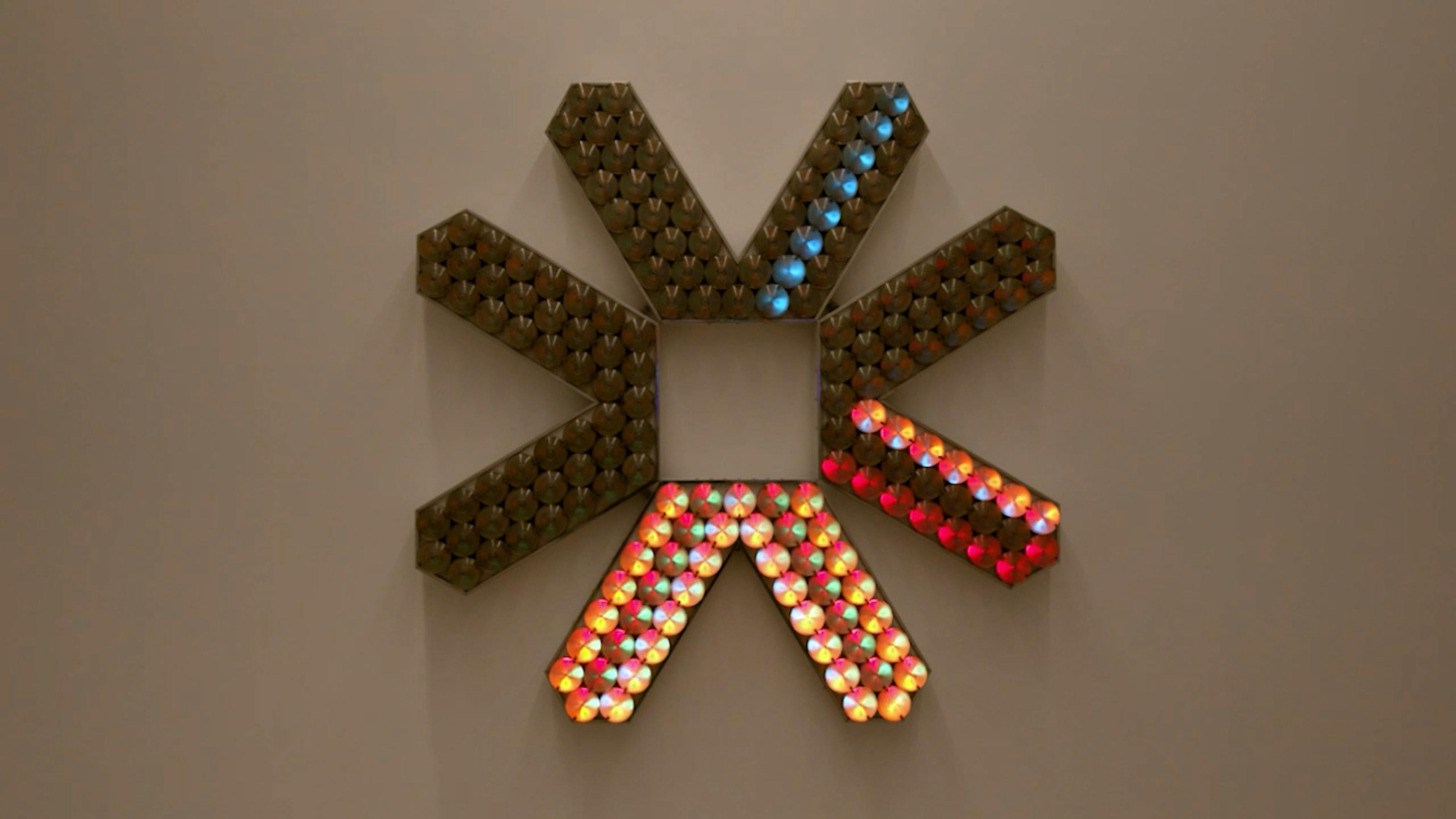 An electronically powered light sculpture with different color lightbulbs lighting up in different sequences.