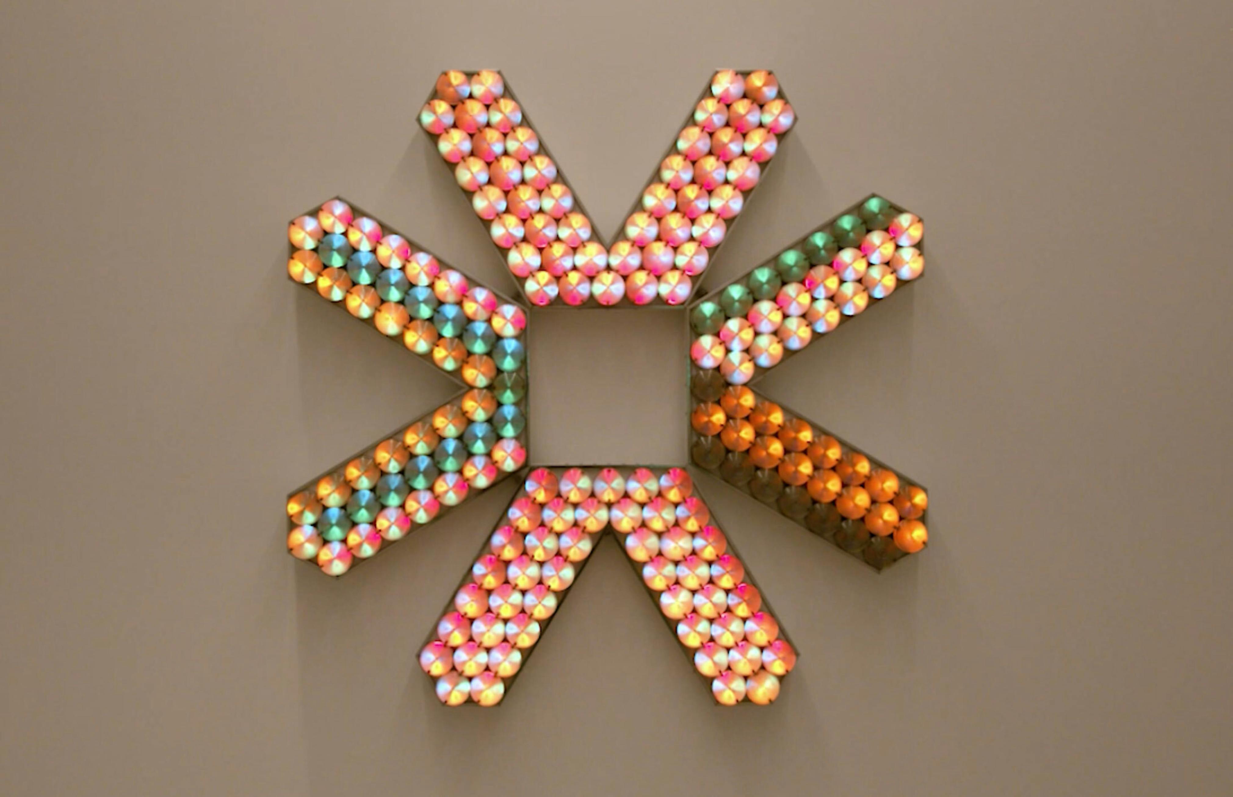 An electronically powered light sculpture with different color lightbulbs lighting up in different sequences.