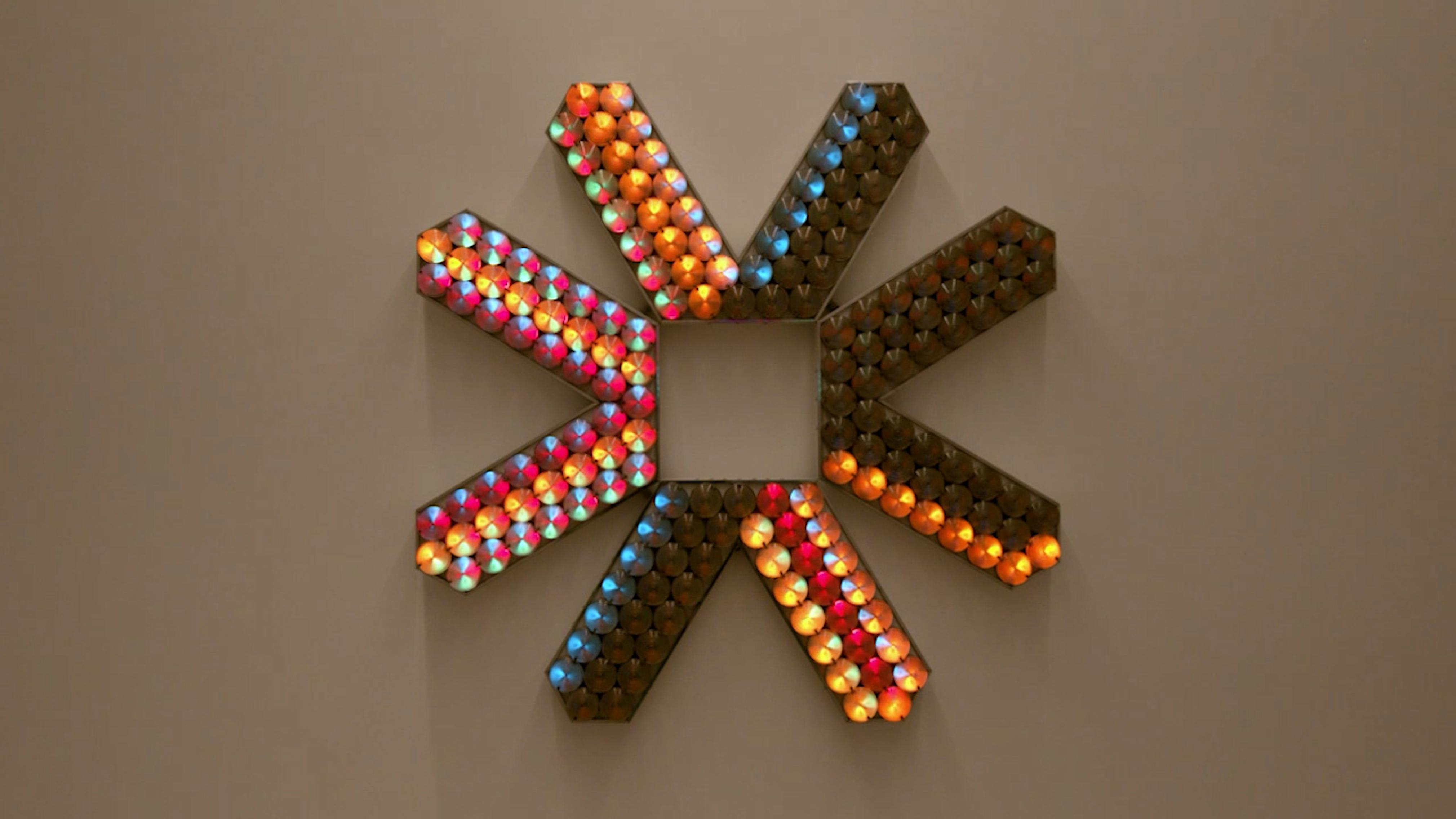 An electronically powered light sculpture with different color lightbulbs lighting up in different sequences.